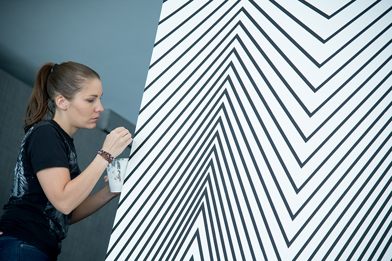 Claudia Comte installing 'Curves and Zigzags,' 2018. // Photo by Jon Gitchoff