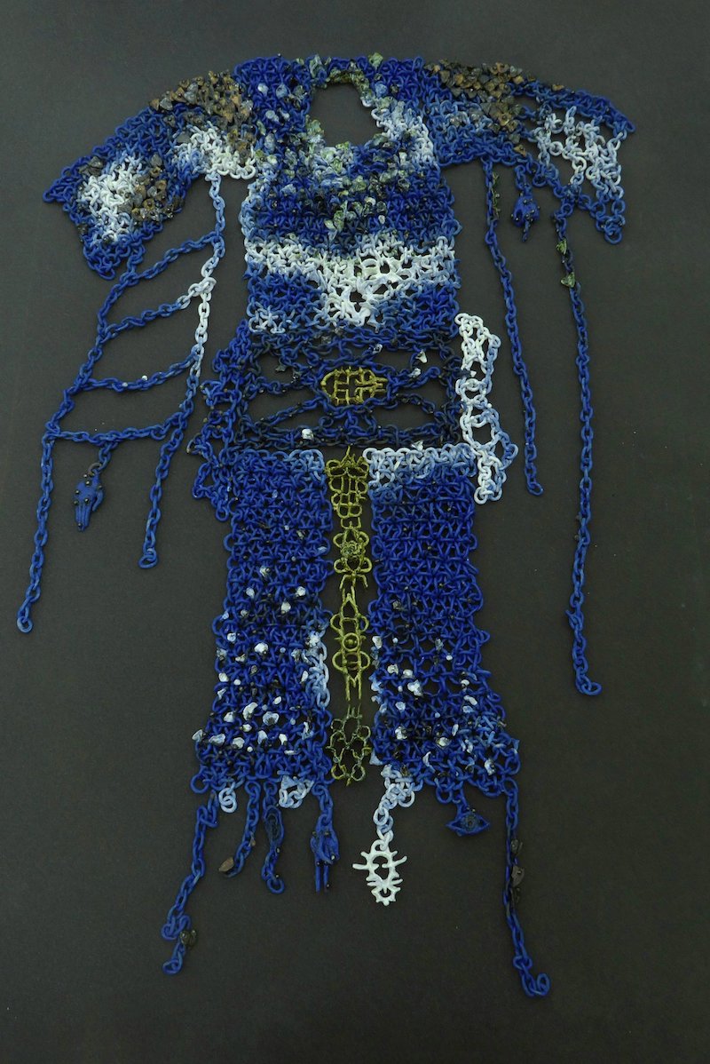 a close up detail of a wearable art work made of blue ceramic pieces