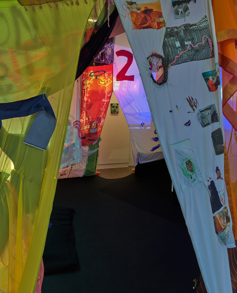 The inside of the blanket fort with a view of a painting through the opening