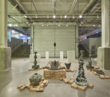 a view of several ceramic sculptures displayed in an exhibition room with two large columns framing them