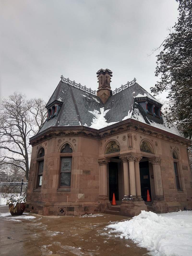 a photo of the cemetery studio space from outside, the building covered in snow