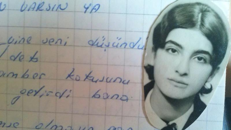 a photograph of the poet semra ertan pictured on top of a notebook of hand-written poetry