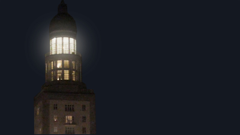 a blurry photograph of a tower light up against the night sky