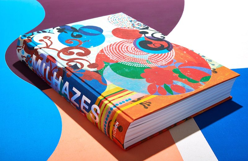 a colorful book of Beatriz Milhazes work photographed on a blue, purple, white and pink background