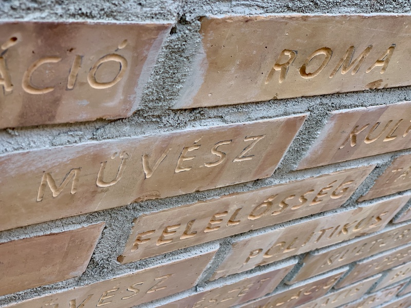 a close up image of a brick wall with Hungarian words written on it