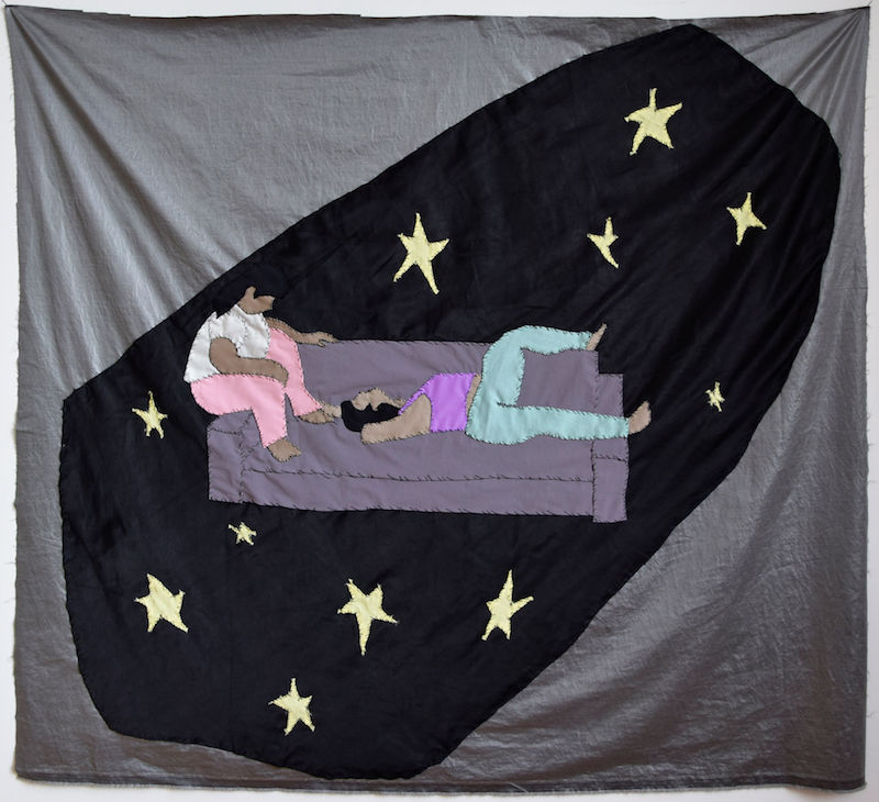 a textile work depicting two people draped on a couch with stars on a black background surrounding them