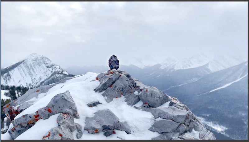 an unknown oval object sits on top of a snowy mountain