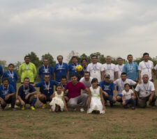 a group of people pose for a photo on a soccer field