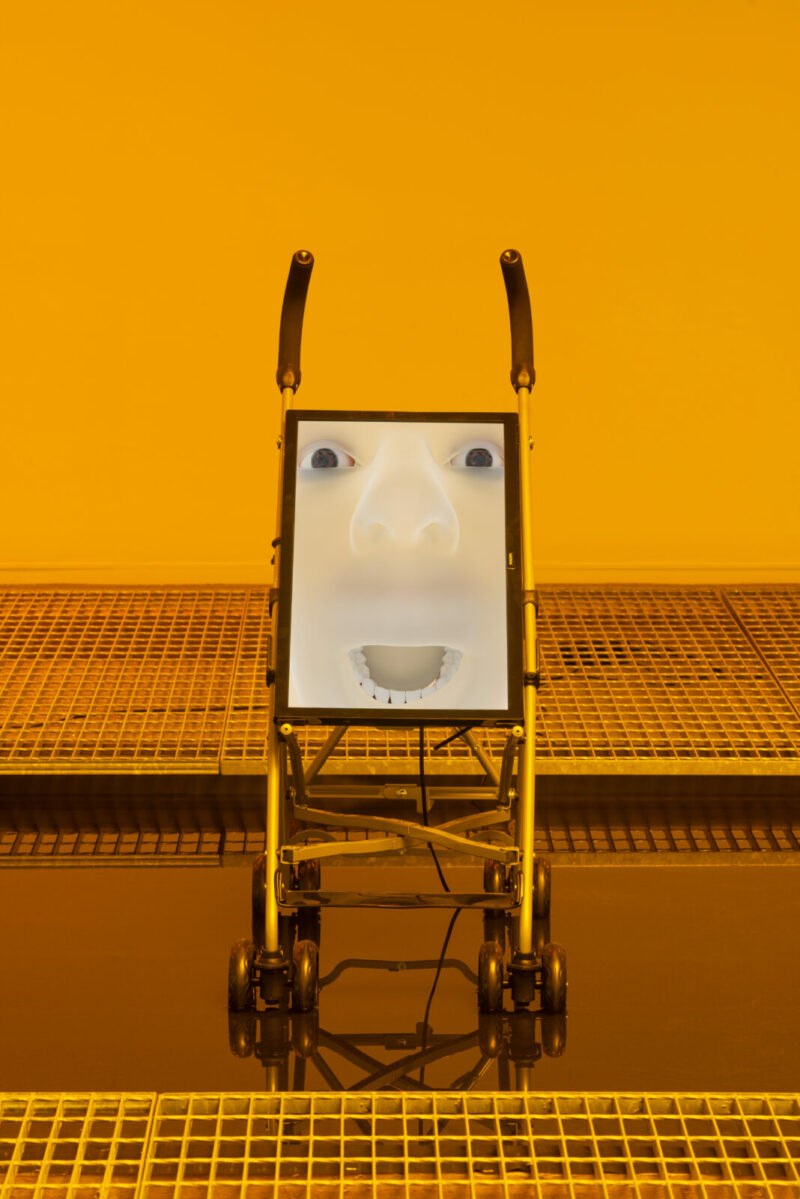 A yellow-toned photograph of an art object that represents a human-machine hybrid