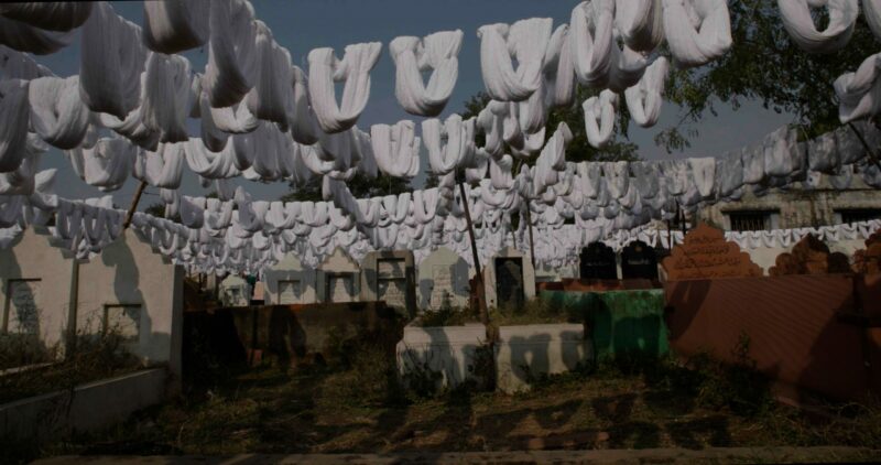A photo of a graveyard and white fabrics hanging on ropes