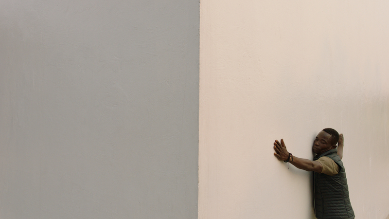 a person stretches out their arms along the length of the White Cube building's outer walls