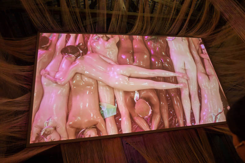 Video still with naked bodies