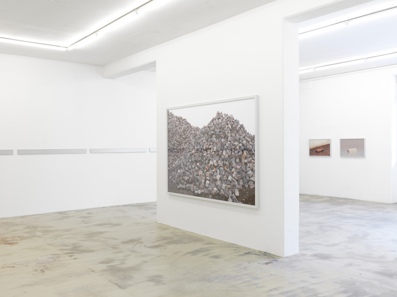 Photo of a large scale photograph of bricks, mounted on a central white wall