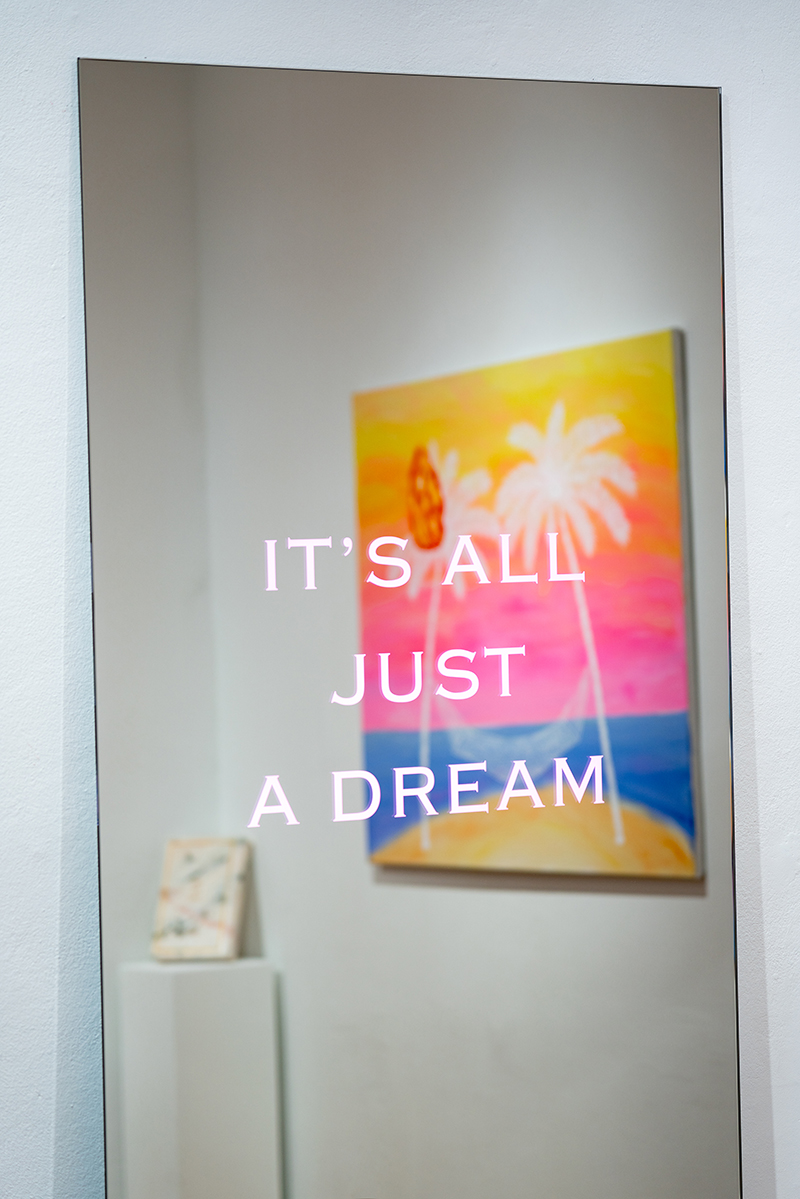 Close up of a mirror on which it has been written "It's all just a dream.'