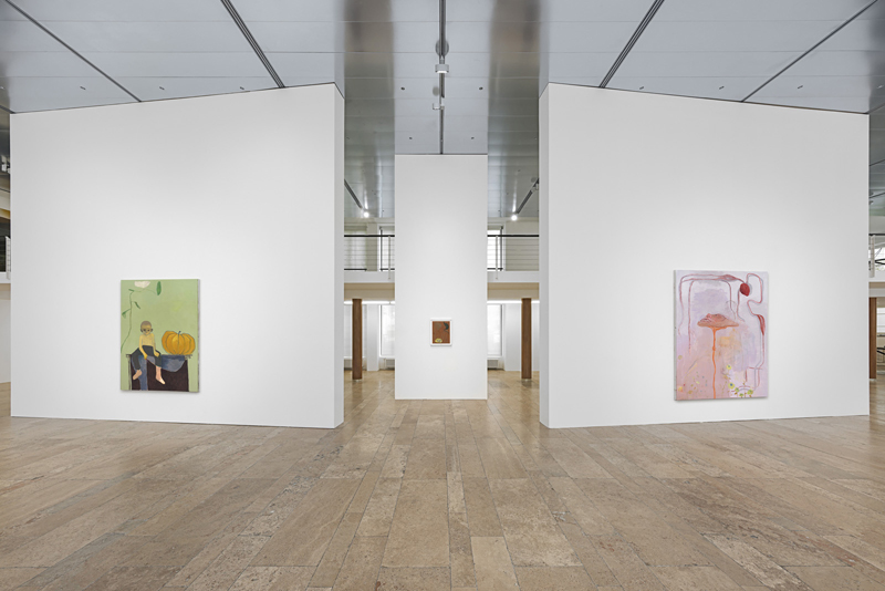 Three white walls with paintings hung on them