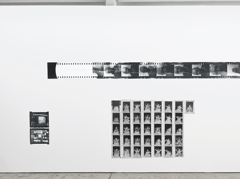 Photo of black and white photographs against a white wall.