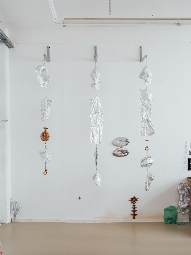 Photo of a hanging sculptural installation made from aluminium casts, chain and bronze