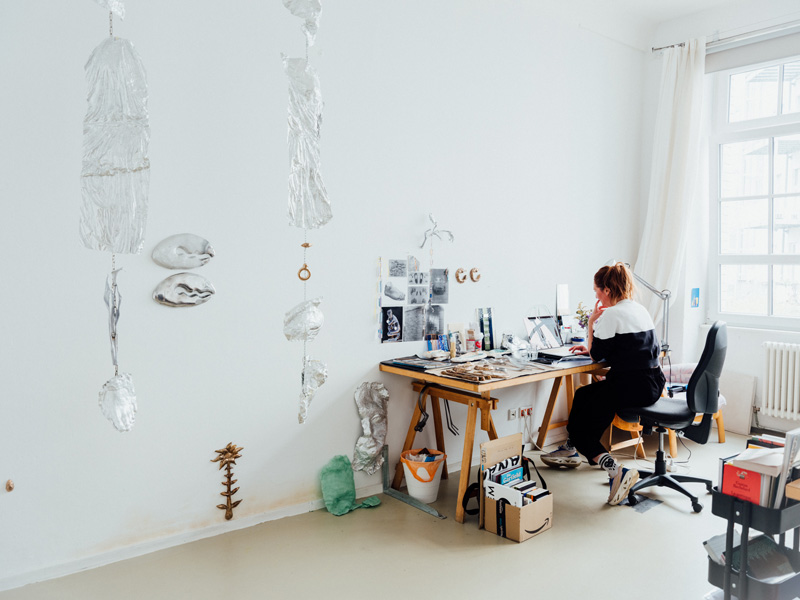 Photo of a female artist sitting at her desk