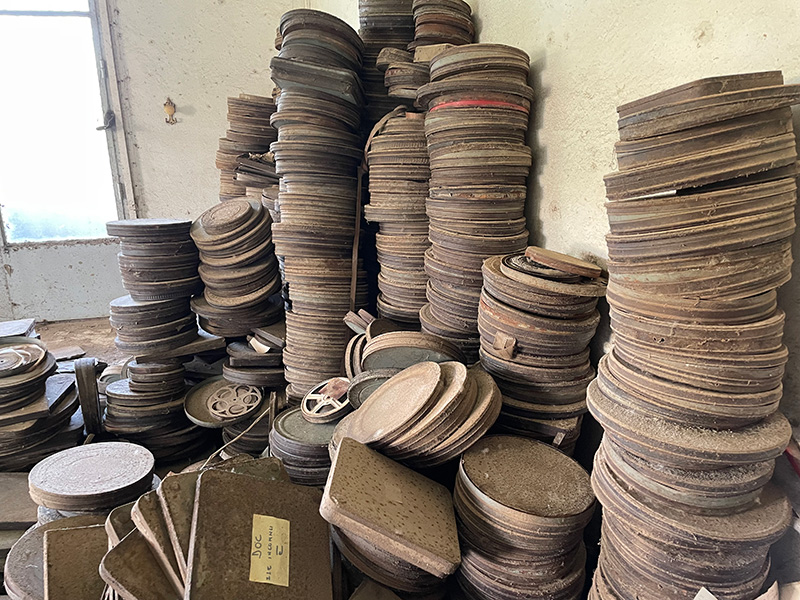 a photo of old,dusty film reels in large piles