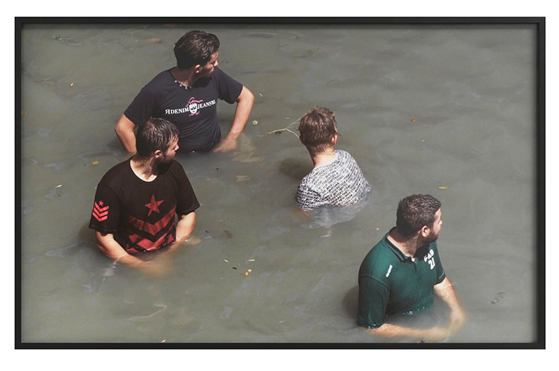 a flatscreen monitor showing teenage boys in dirty water