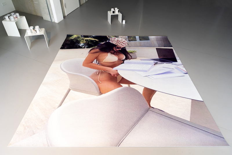 rug on the floor with the image of kim kardashian studying in her bikini printed on it 