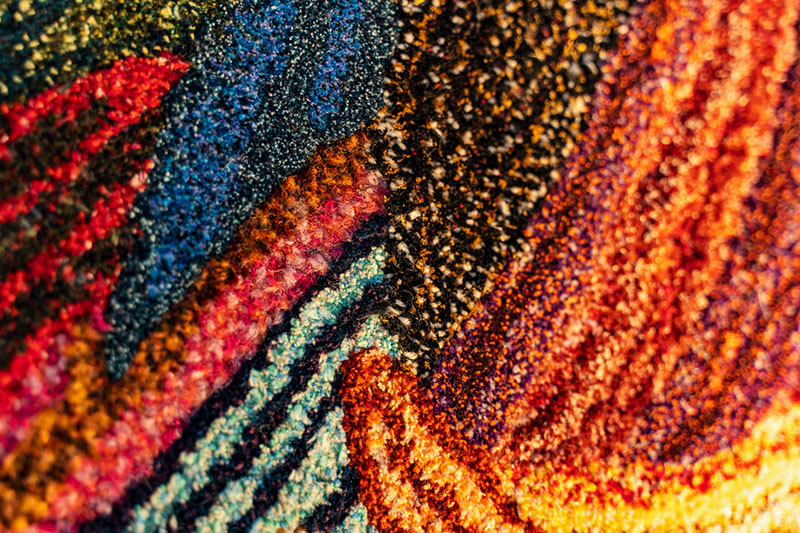 close up of the texture of a colourful handmade rug