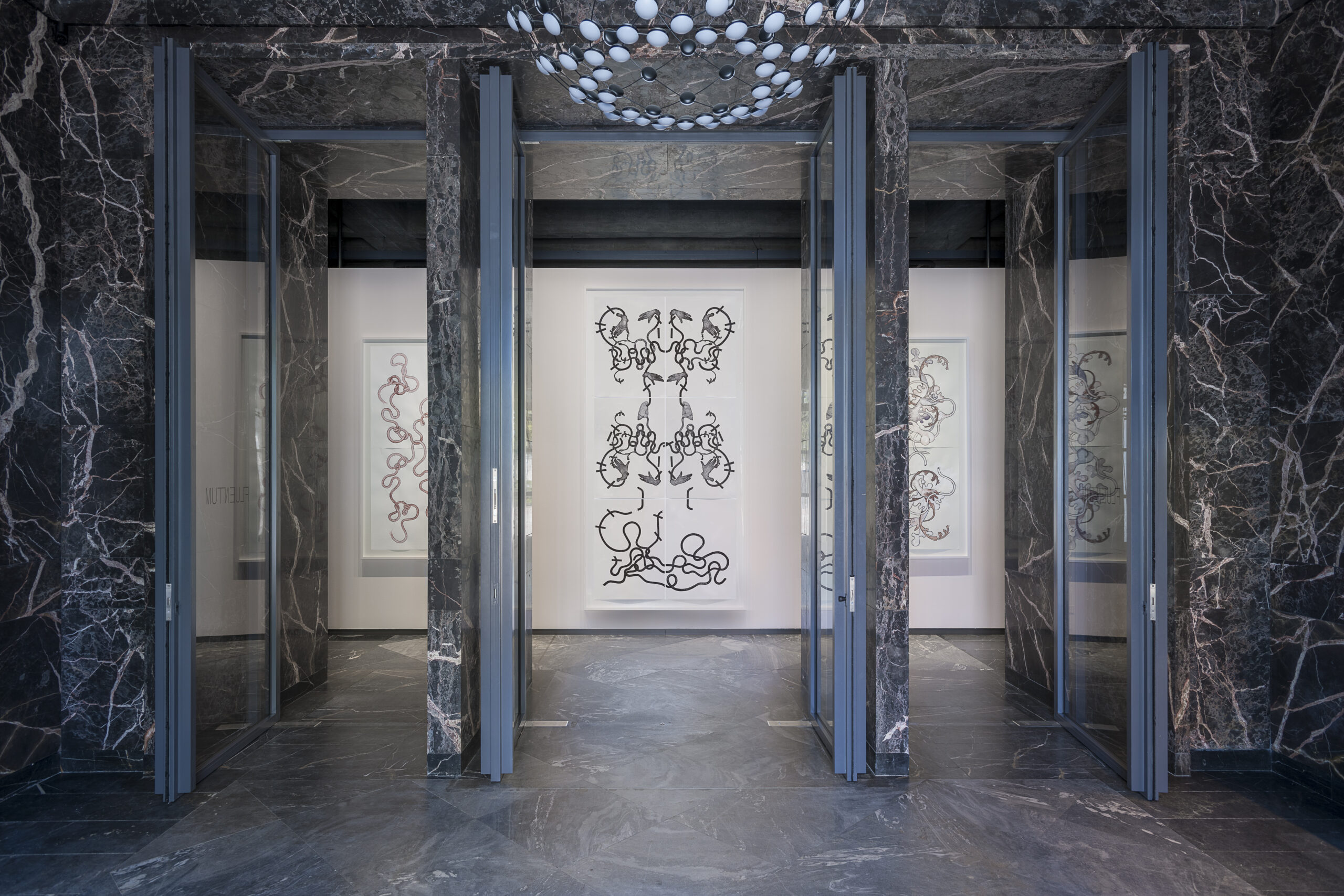 large framed drawings presented in a luxurious room made of marble