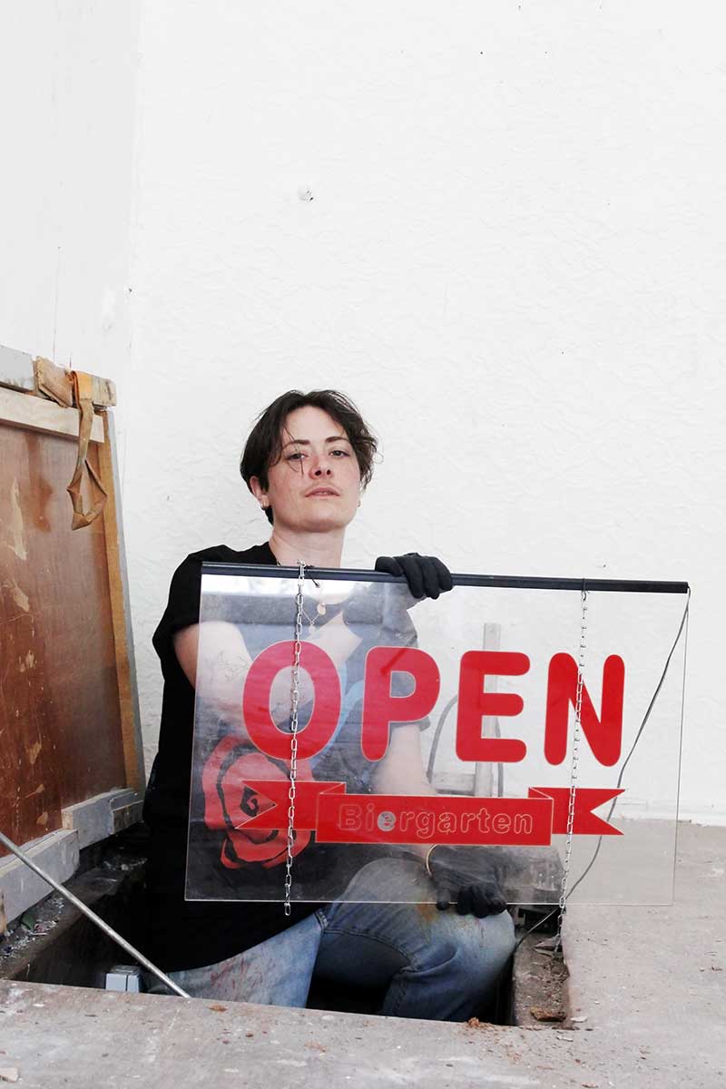 Elif Saydam holds a sign with open written on it