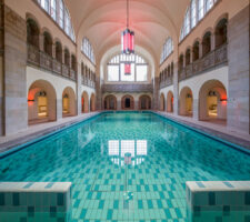 Large indoor swimming pool in Art Deco design in a two story high hall with arches