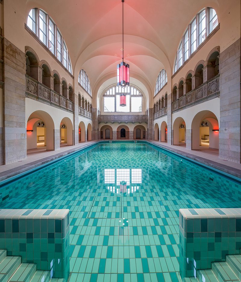 Large indoor swimming pool in Art Deco design in a two story high hall with arches
