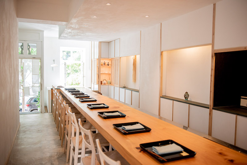 minimal Japenese interior designed restaurant room with long table, chairs and sets