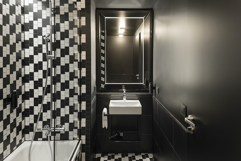 hotel bathroom in black and white checkered pattern with sink and bath tube