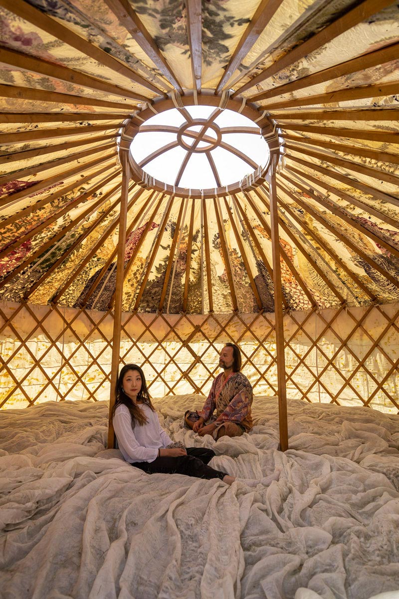 Two people sitting inside a yurt