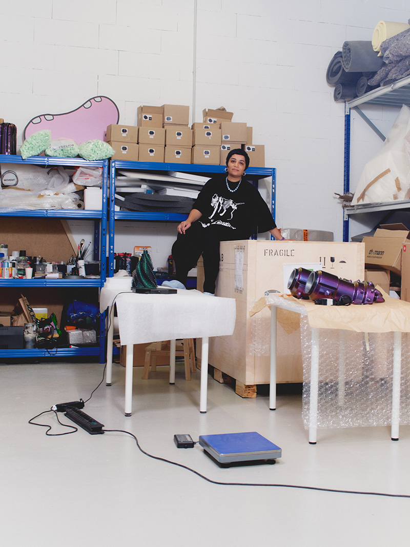 Monira Al Qadiri sitting on a crate in her studio