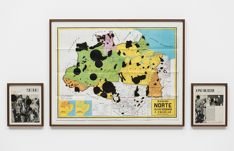 Three framed images, two black and white images from a newspaper with groups of people and in the middle a bigger frame with a map of Brazil containing black spots throughout.