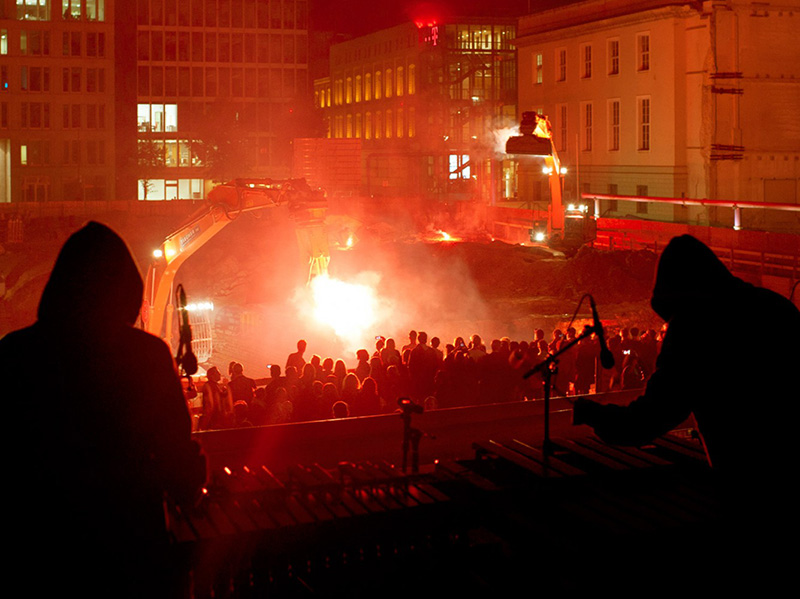 A firey blast in an excavation pit at night in a city