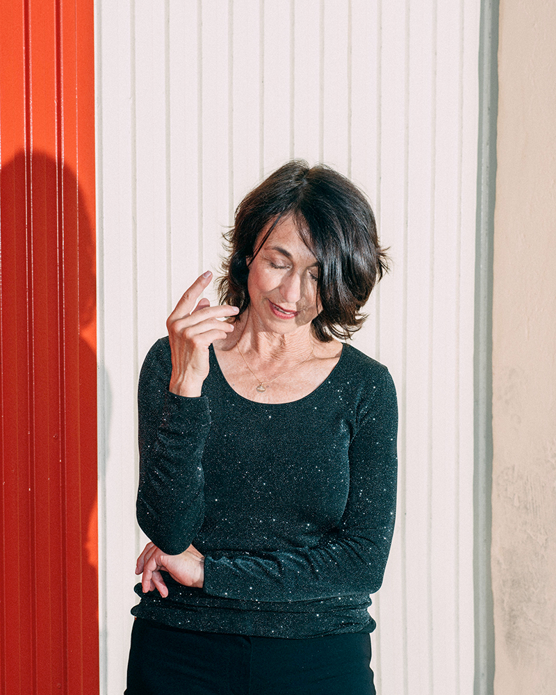 A portrait of a woman in front of a white and red wall