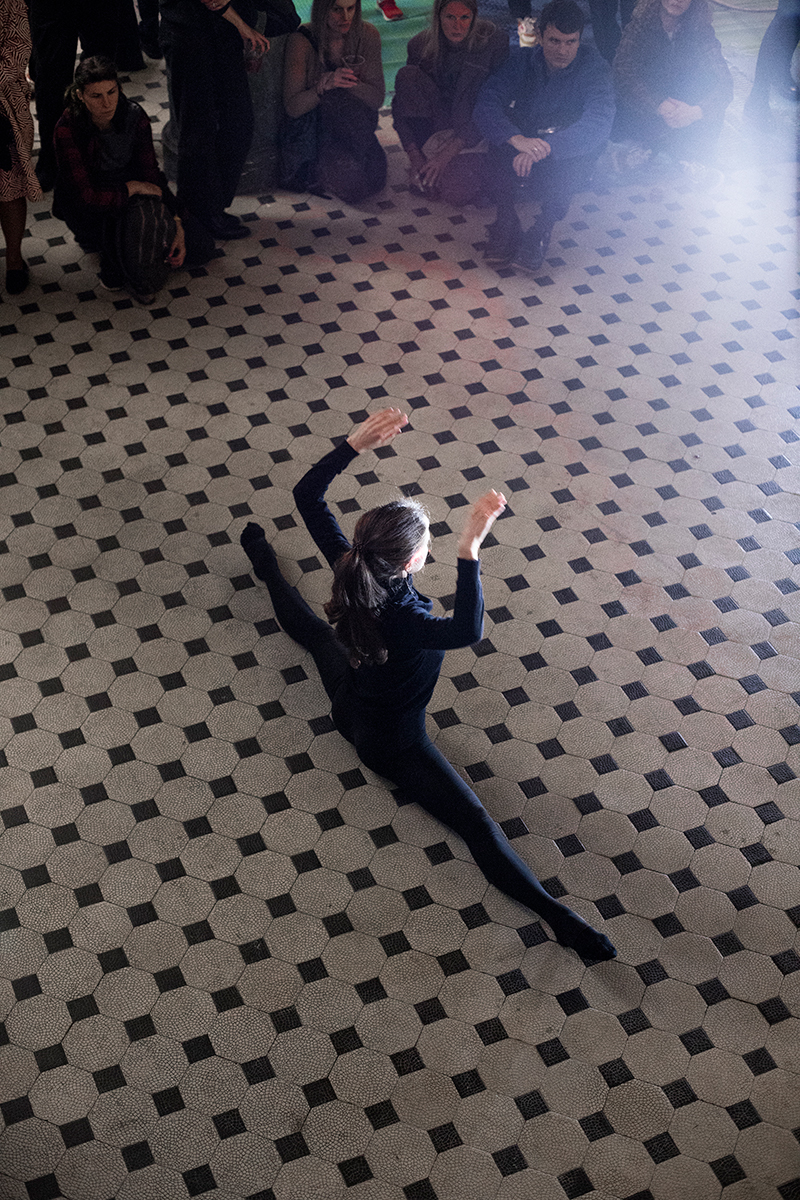 a female dancer doing the splits on a tiled floor