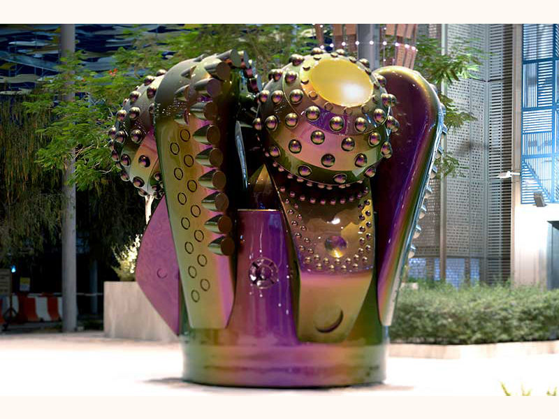 A large aluminum sculpture that looks like a crown, painted with tone-shifting car enamel. It actually depicts an enlarged version of an oil drill.