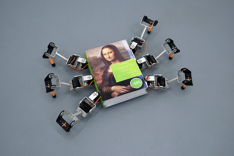 A small robot made from a book on the Mona Lisa with six robotic legs attached
