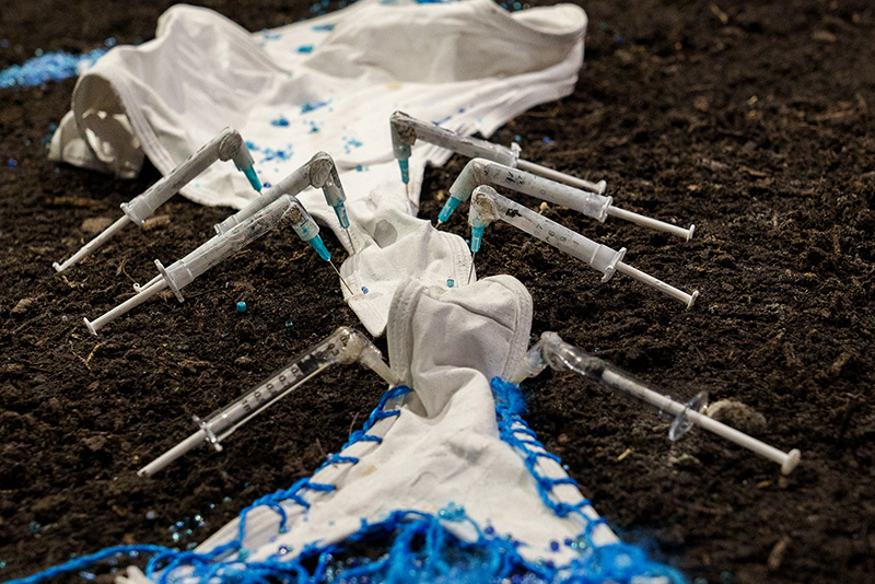 augmented syringes on a pile of soil