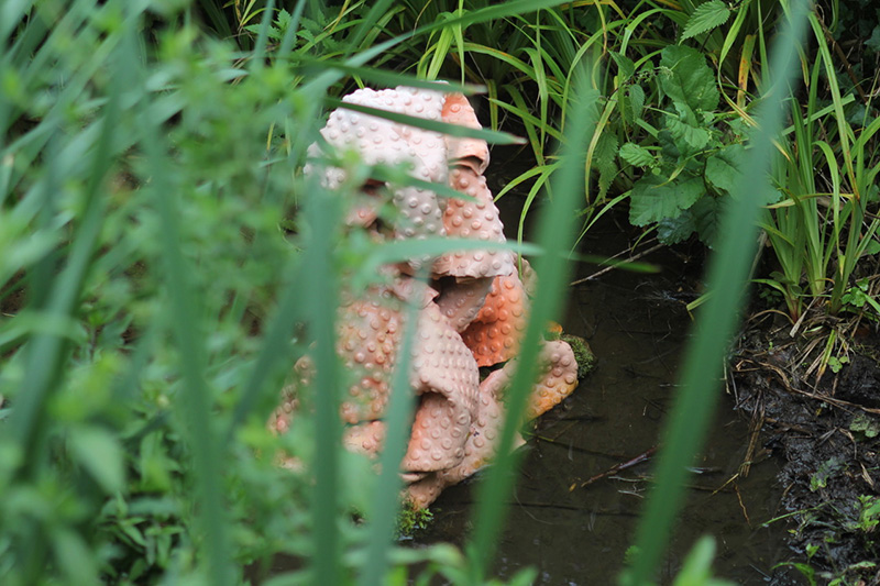 A pink sculpture sitting in a stream