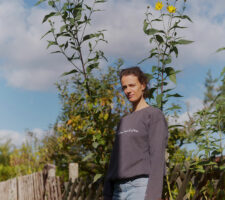 A woman standing in front of sunflowers photographed a little from below