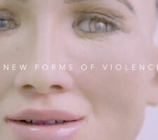 a close up of a face of a robot made to look like a female upon which the text "new forms of violence" has been written
