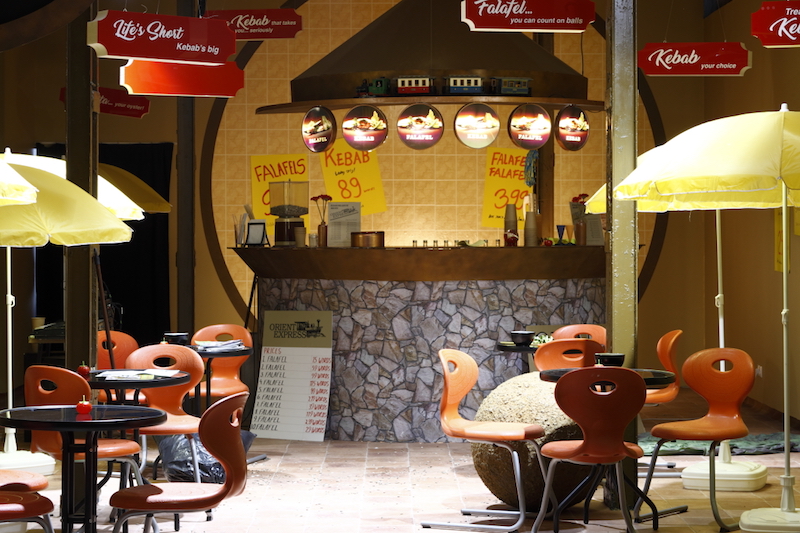 dimly lit set design for a kebab shop installed in a museum