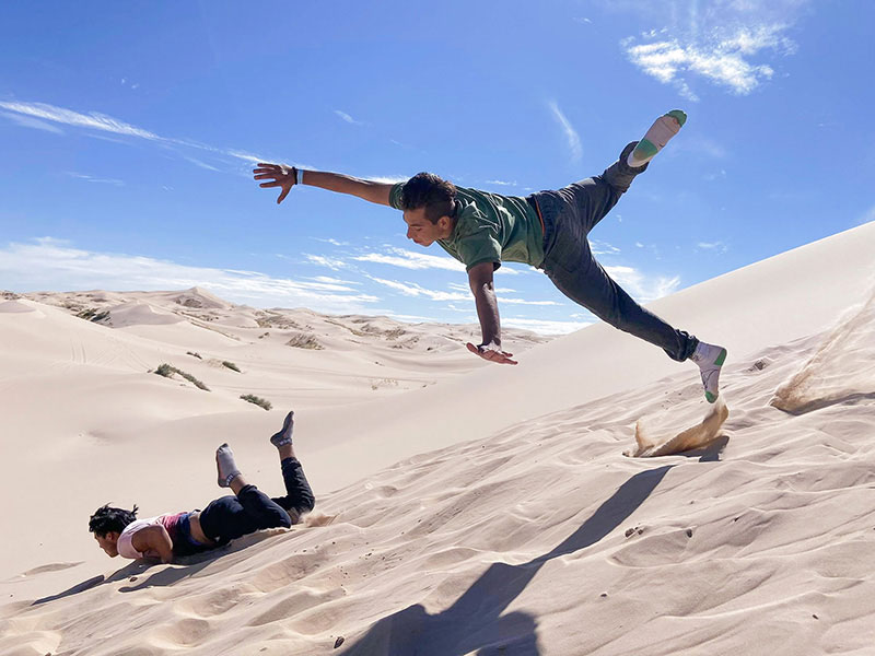 Photo of kids jumping in sand