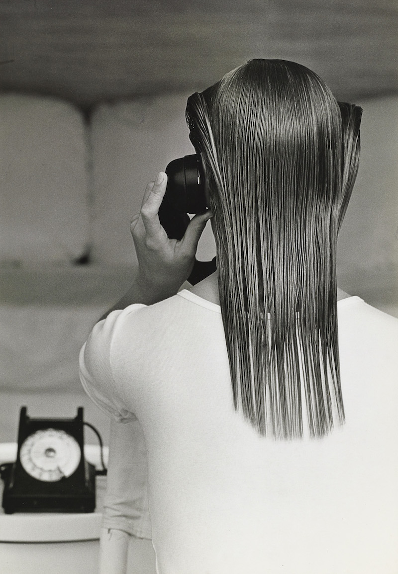 Black & White Photograph of a Woman seen from the back on the telephone